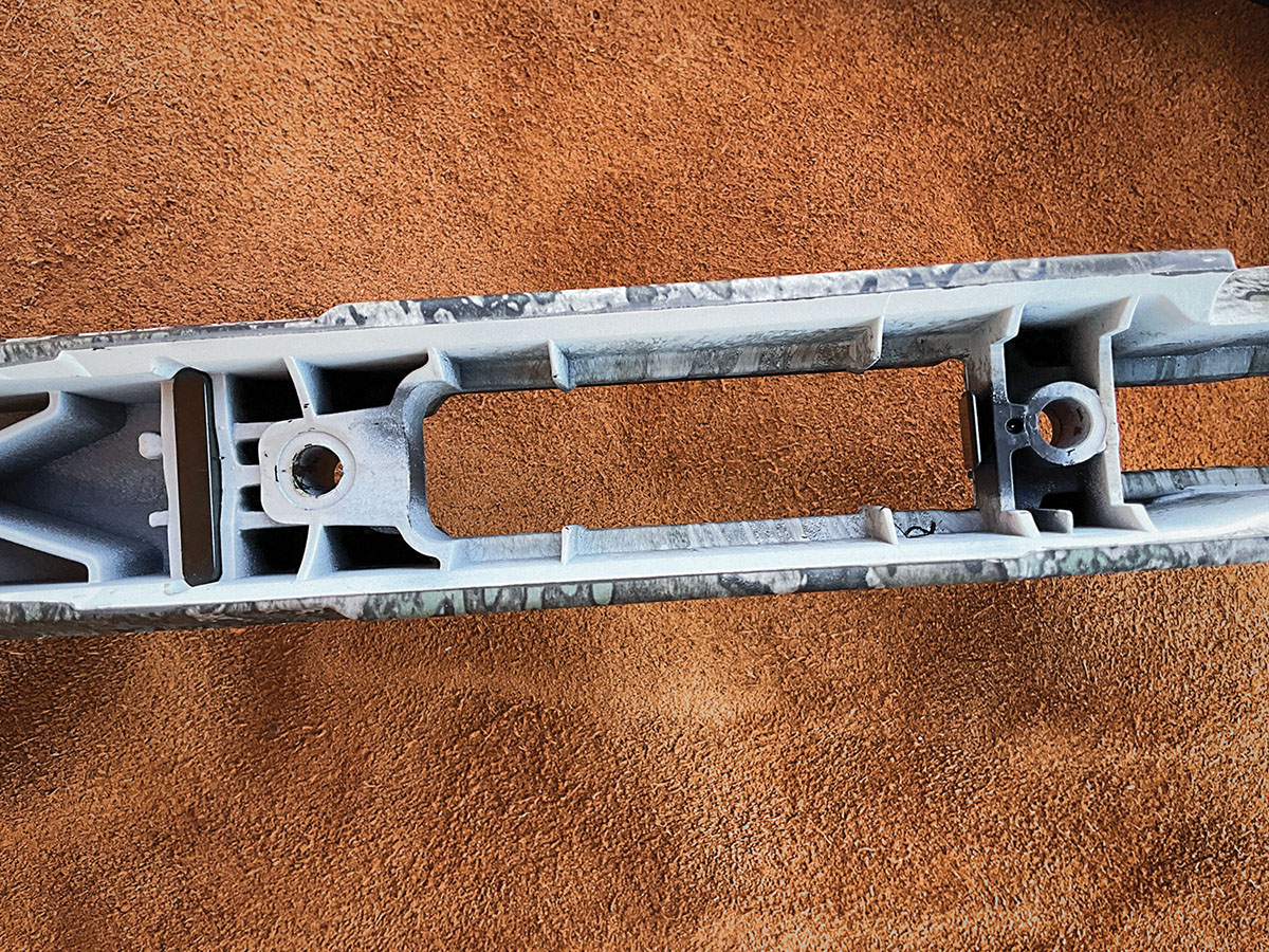 The recoil lug embedded in the stock fits tightly into a slot in the receiver  to prevent rearward movement. Two plastic pillars maintain the proper receiver-to-stock interface.